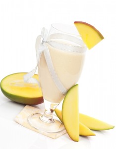Delicious mango milk shake with fresh mango fruit isolated on white background. Refreshing summer drink.